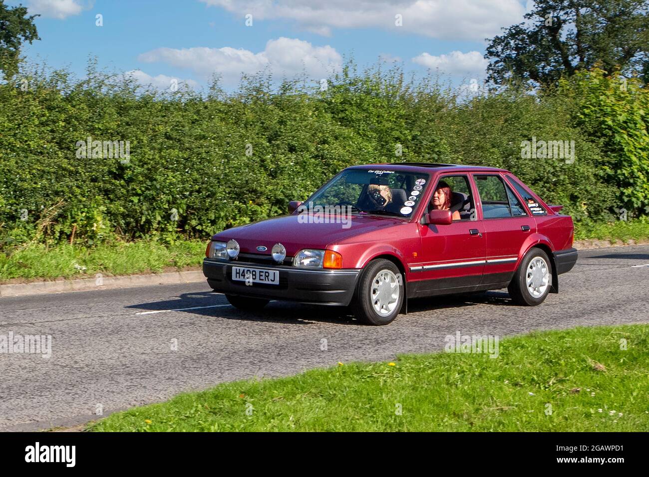 1990s, 90s, 1990 red Ford Escort Eclipse classic vintage car arriving at the Capesthorne Hall classic car show. Stock Photo