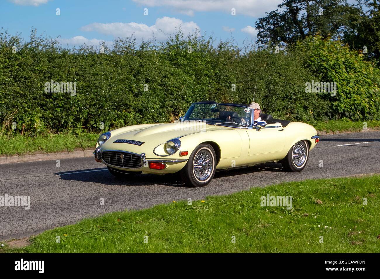 1974s, 70s, 1970s yellow Open ' E' type auto classic vintage car arriving at the Capesthorne Hall classic car show. Stock Photo