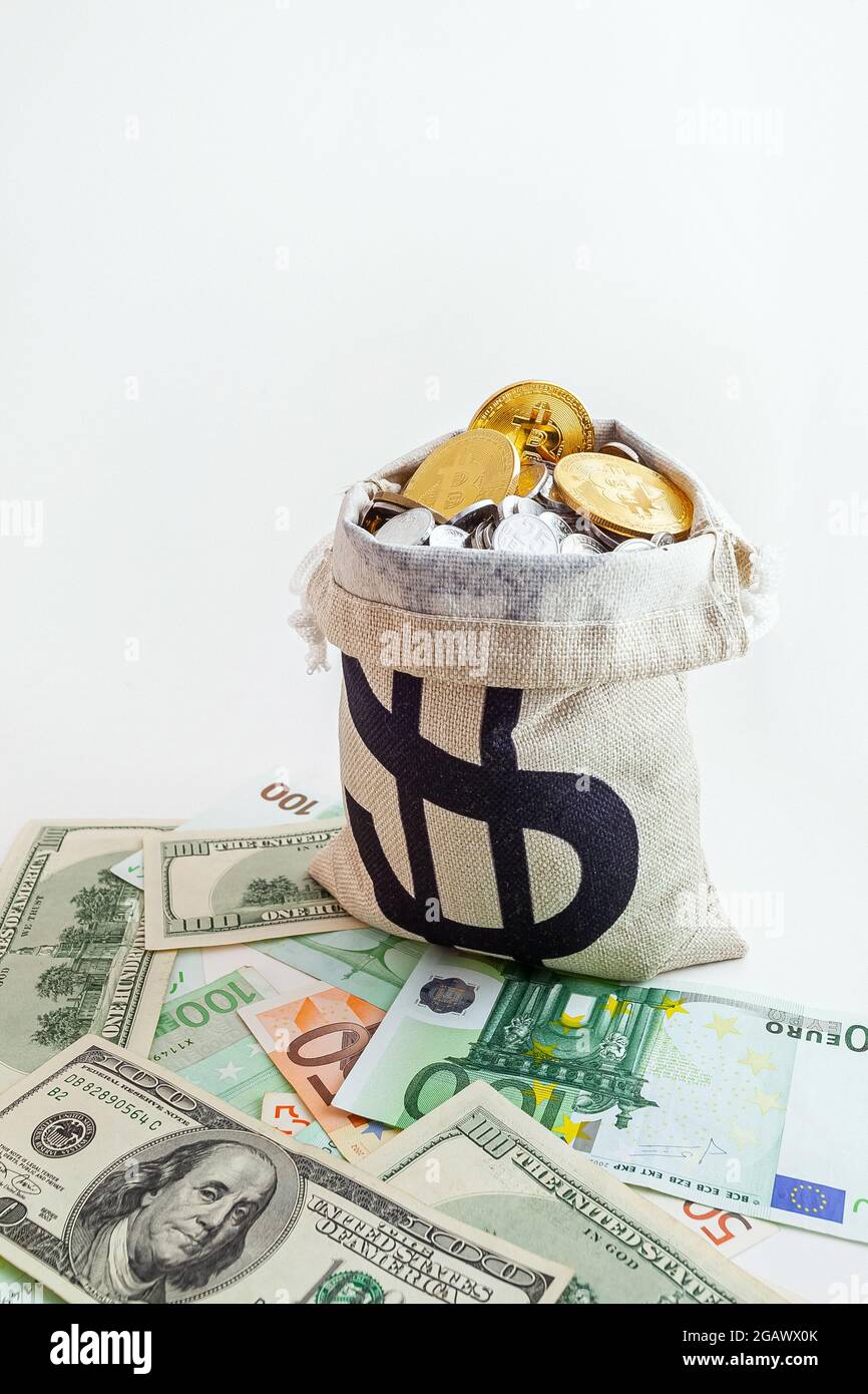 pouch with coins and bitcoins on us dollar and euro banknotes Stock Photo