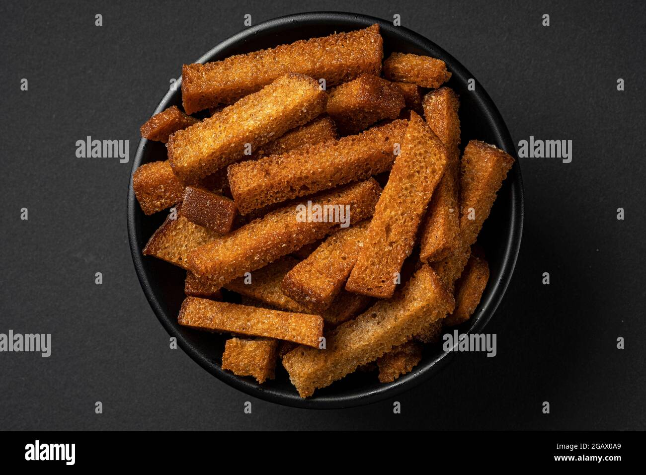 Bowl of rye croutons on black background  Stock Photo