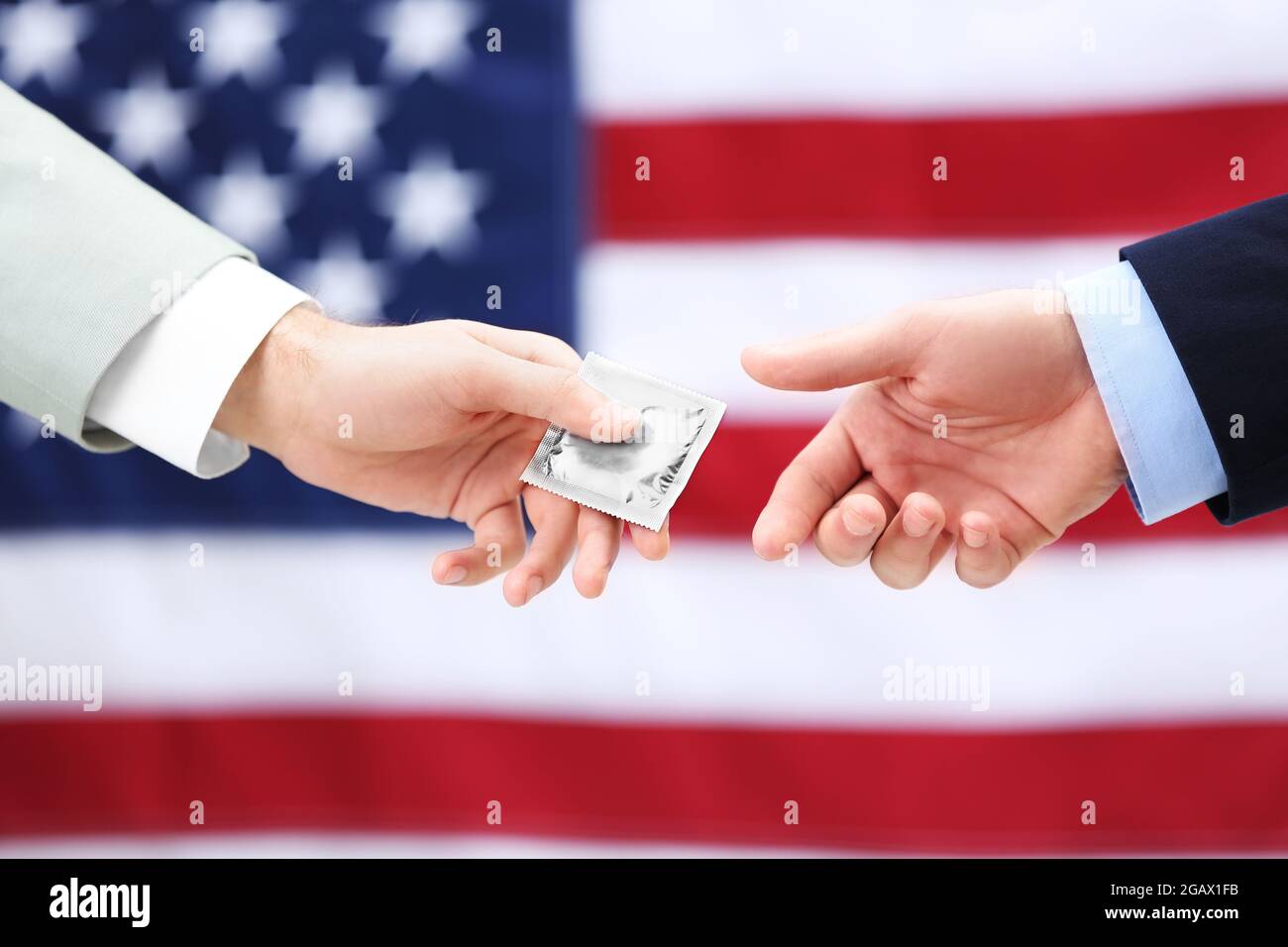 One groom giving a condom to another man on American flag background
