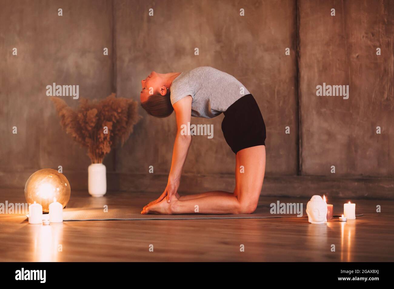 Young female meditating with closed eyes and clasped hands while