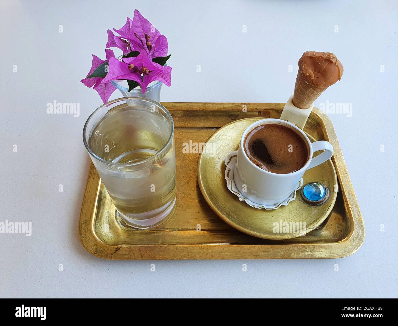 Delicious, strong and aromatic Turkish coffee. Serving with delicious ice cream and a beautiful pink flower. Stock Photo