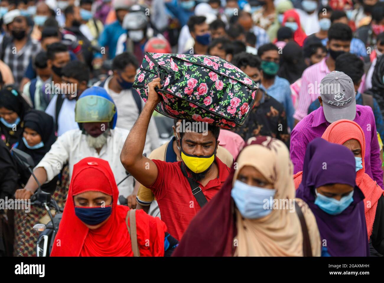 People return to their work areas in Dhaka after government relaxed the lockdown restrictions. Thousands of Bangladeshi garment workers returned to Dhaka after the government relaxed the Lockdown restrictions for all export-oriented factories which were earlier imposed to curb the spread of Covid-19 at the Munsiganj ferry terminal outskirt of Dhaka. Stock Photo