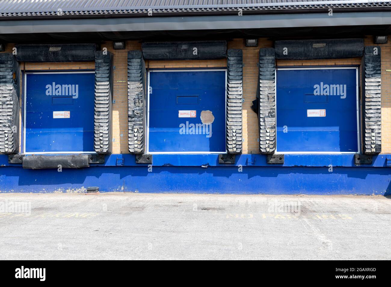 Row of loading docks with closed doors at an industrial warehouse. Stock Photo
