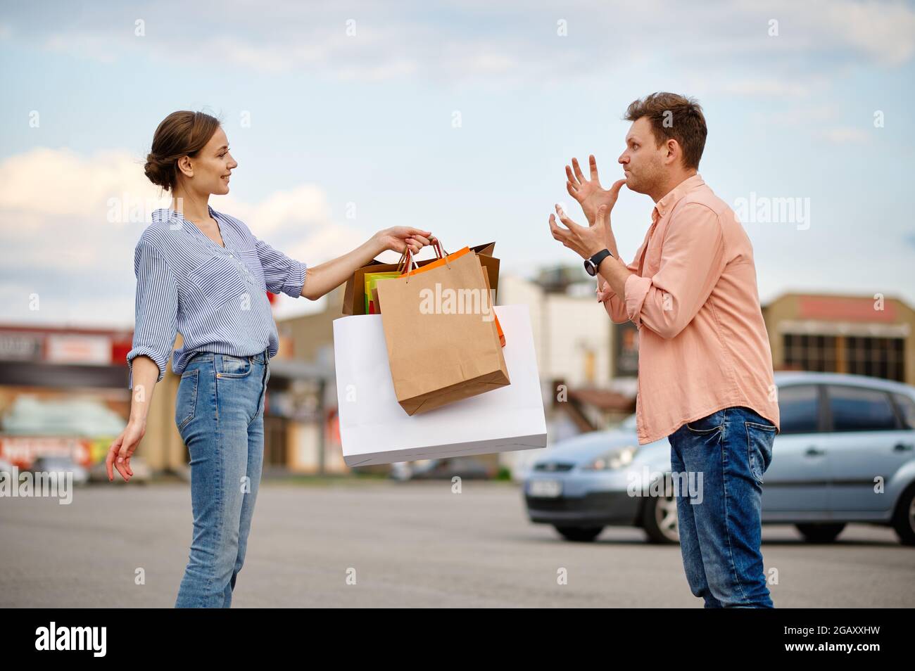 Angry husband and smiling wife on parking Stock Photo