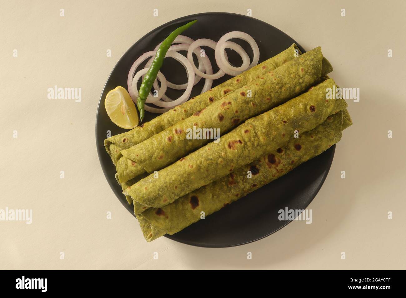 Indian flatbread made with whole wheat flour kneaded with pureed Indian spinach and spices. Popular in India as palak paratha. Stock Photo