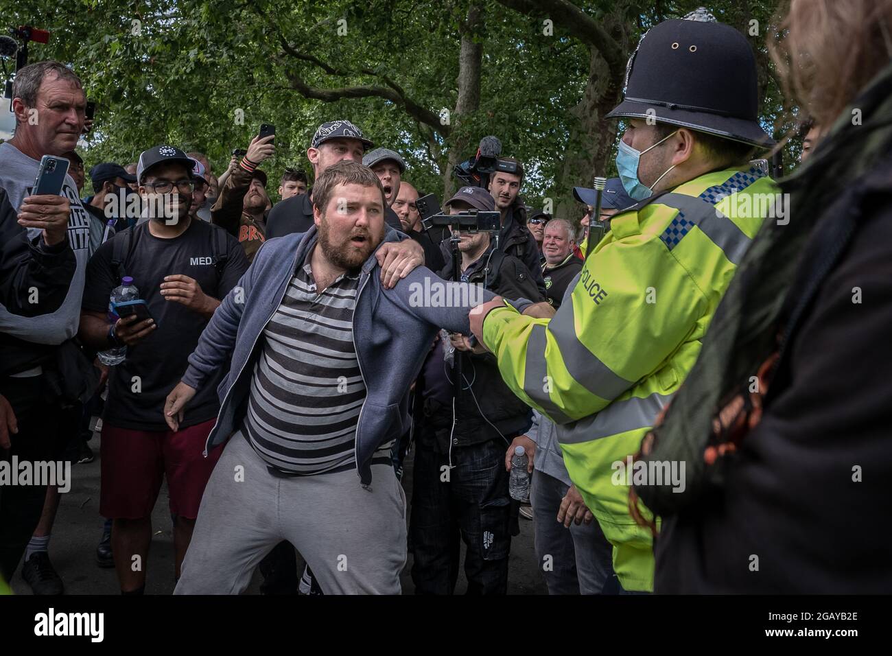 London, UK. 1st August, 2021. Police attempt to remove and detain a man