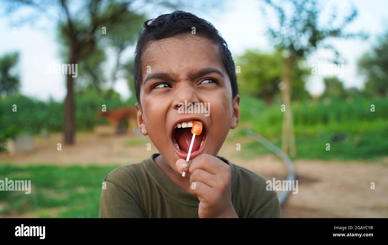 Naughty Indian little boy with candy bar. Cute little Indian/Asian boy