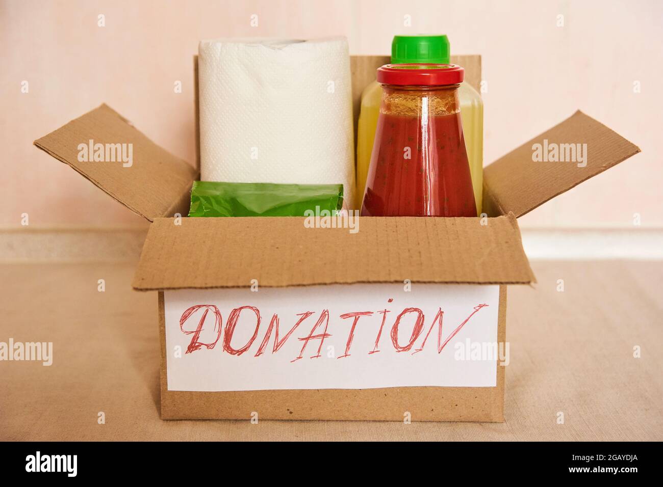 Full donation box on kitchen table. Food delivery concept. helping poor family and the elderly