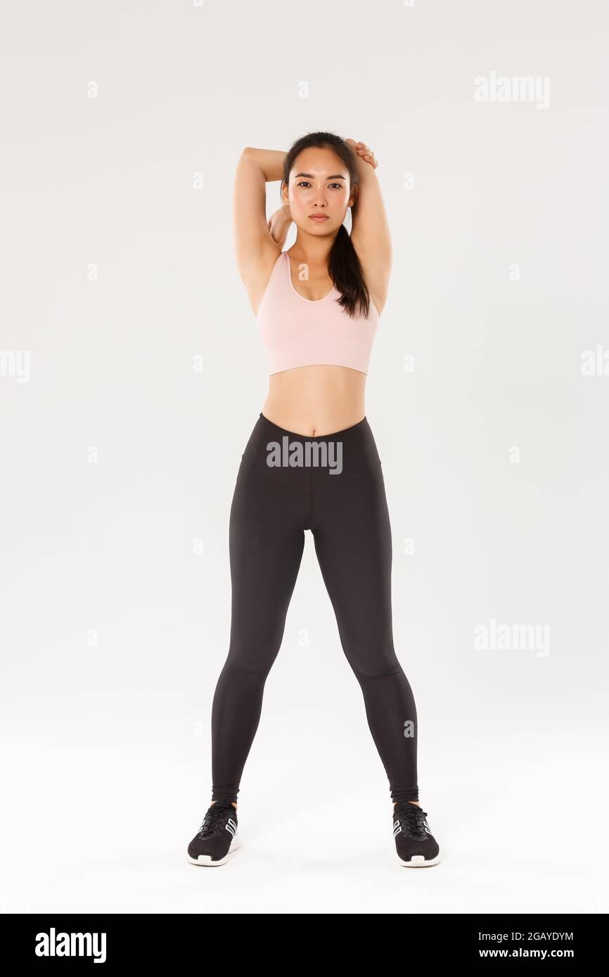Full length of focused and motivated asian female athelte, brunette fitness  girl looking determined while perform stretching exercises, warm-up before  Stock Photo - Alamy