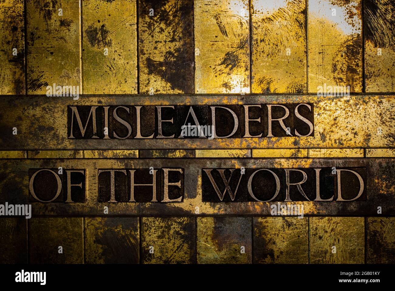 Misleaders Of The World text on grunge textured copper and gold background Stock Photo