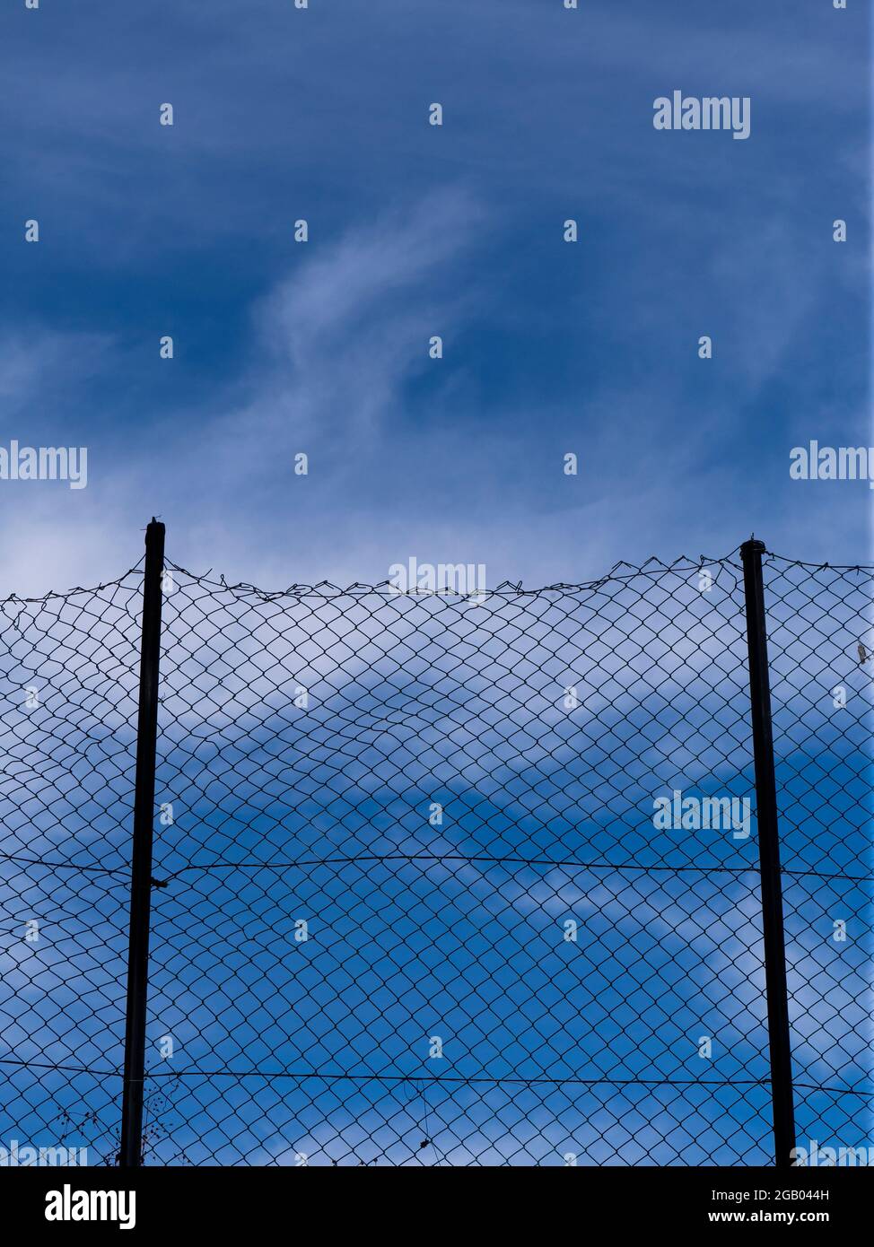 Metal mesh fence and sky Stock Photo