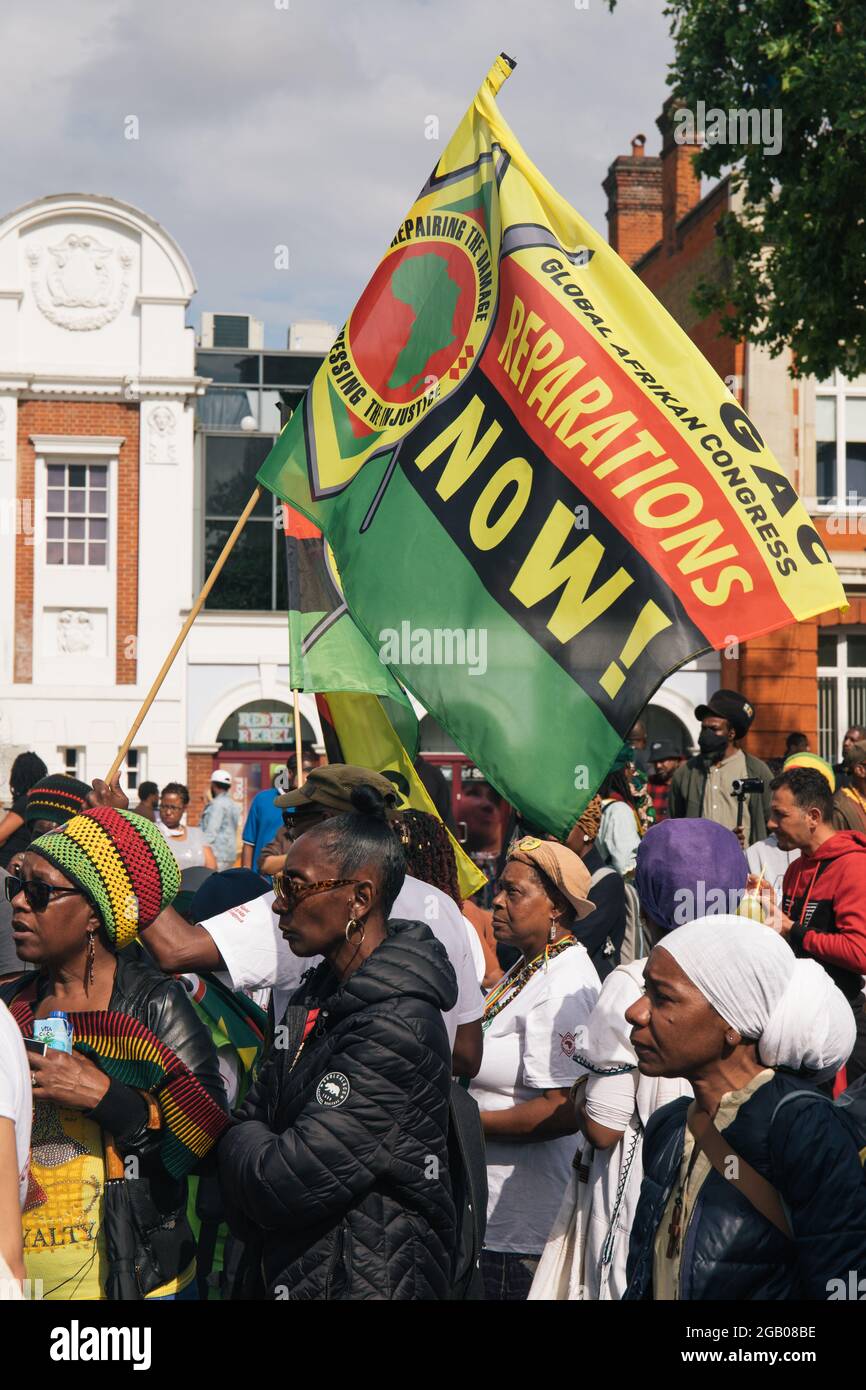 London, England, UK 1st August 2021 A coalition of protestors block Brixton Road behind the banners of Reparation Rebellion and Extinction Rebellion, on Afriikan Emancipation day. Credit: Denise Laura Baker/Alamy Live News Stock Photo