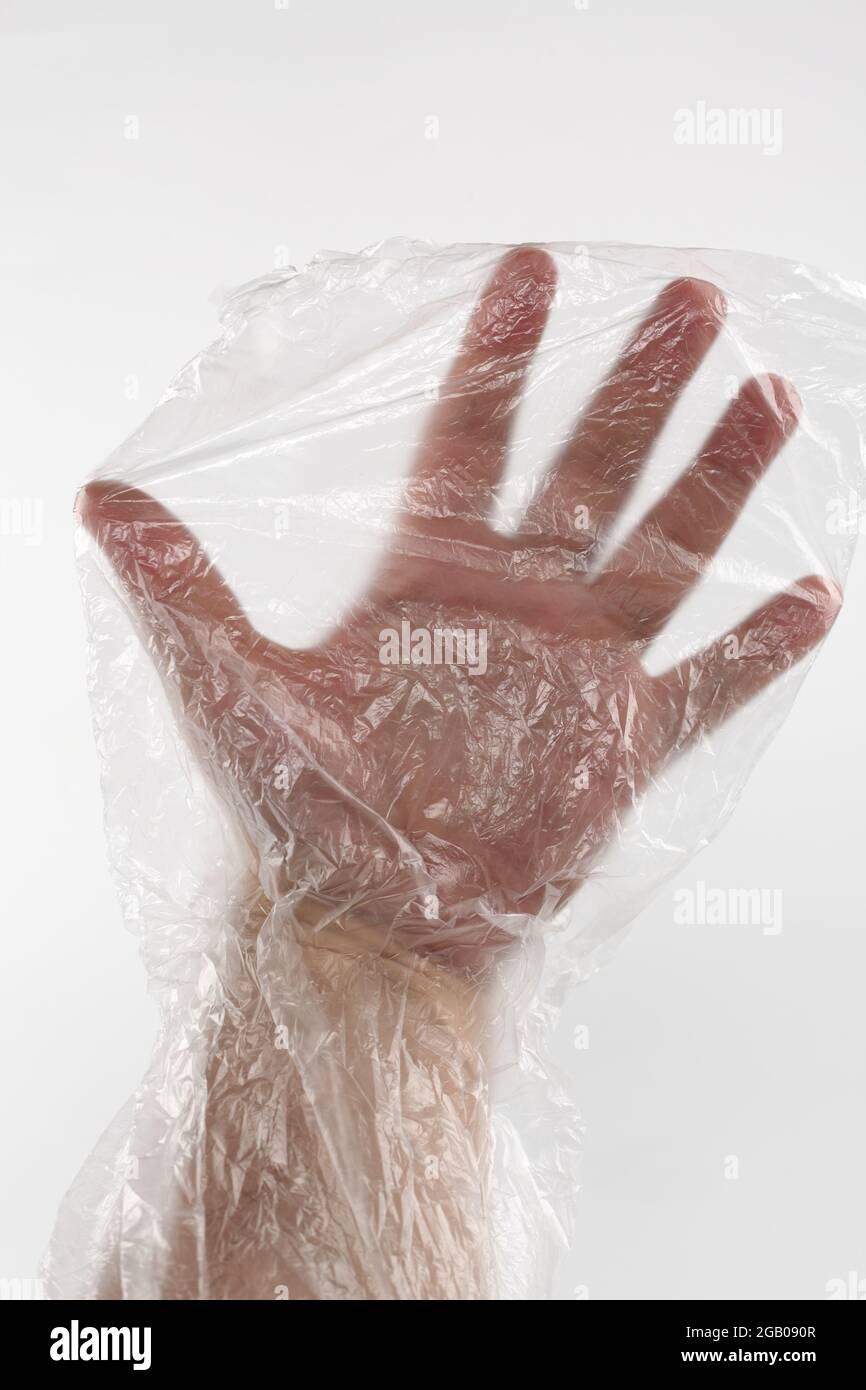 Male hand in plastic wrap. Man's hand in a plastic bag. Male hand inside a transparente wrap bag. Stock Photo