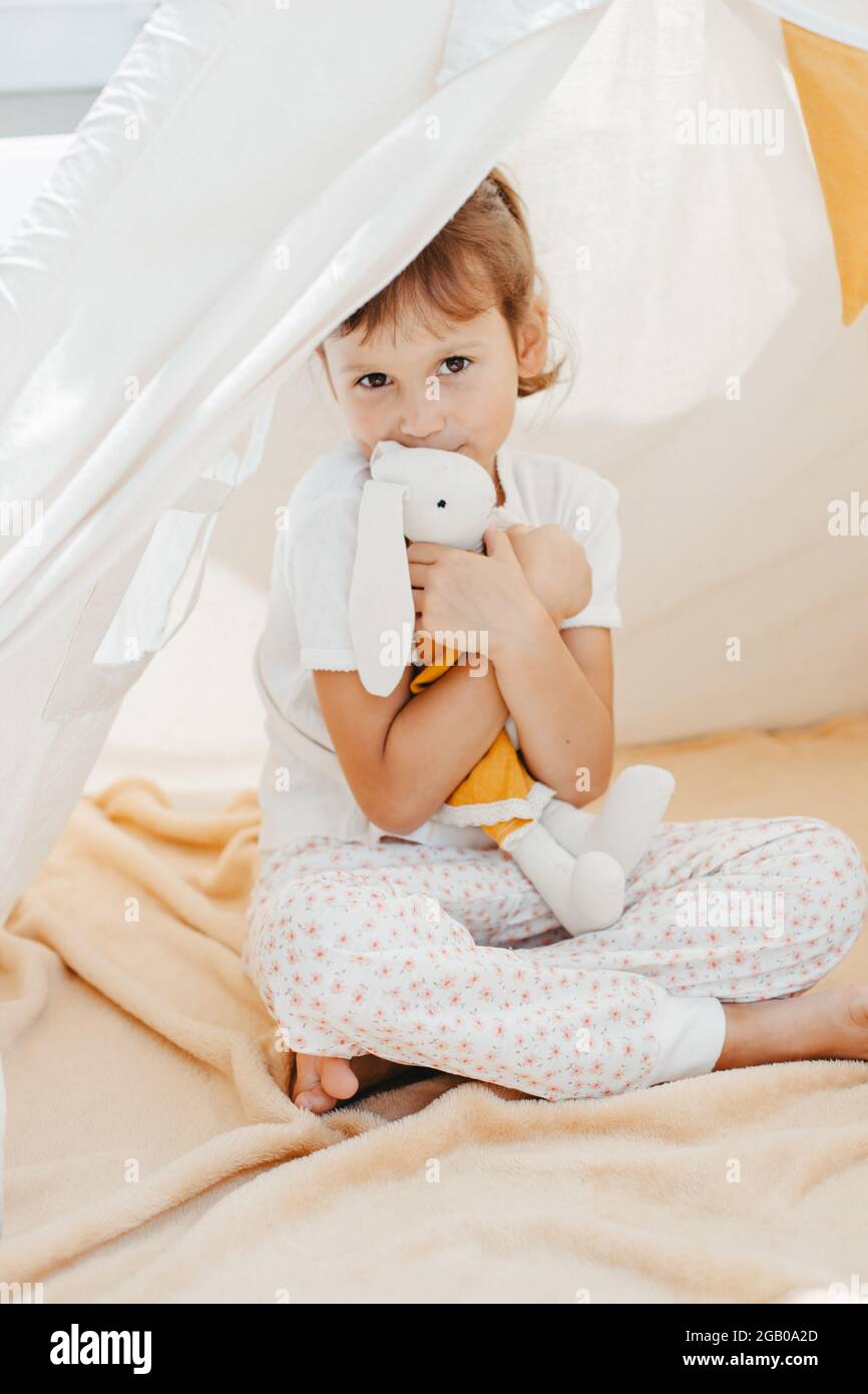 cute girl playing in teepee with fabric tilda bunny at home Stock Photo ...