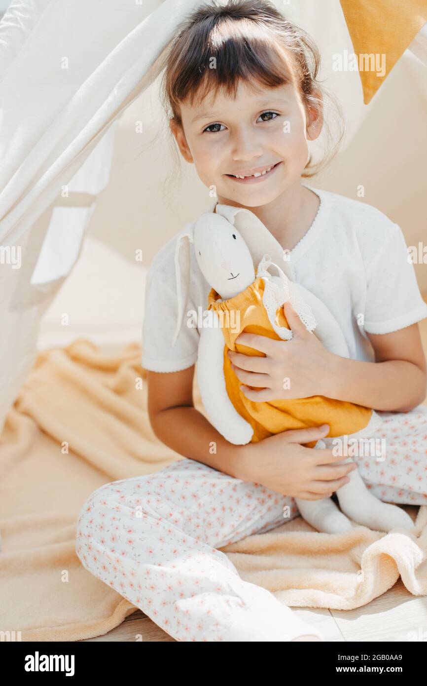 cute girl playing in teepee with fabric tilda bunny at home Stock Photo ...