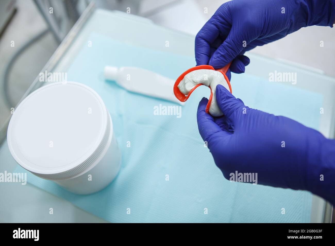 Orthodontist using dental putty to make teeth impressions of a patient