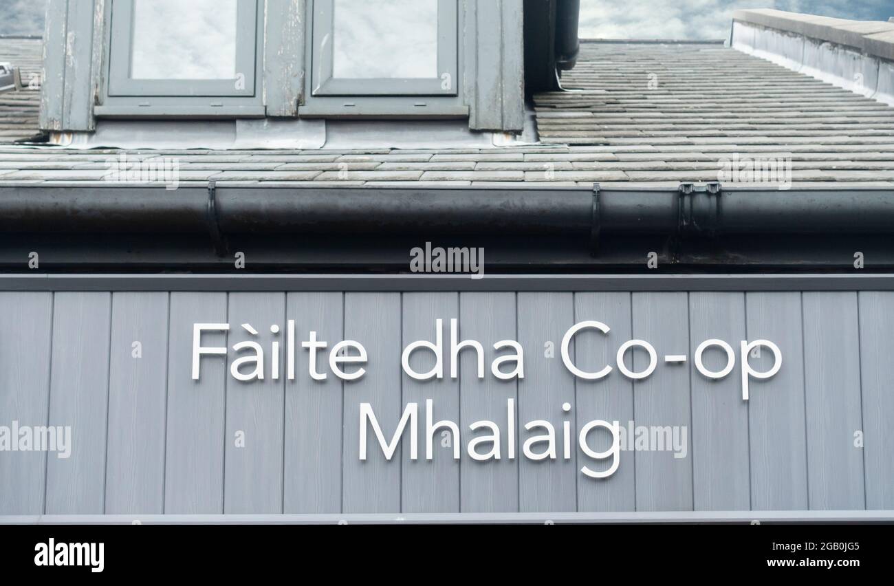 Scottish Gaelic sign 'Fáilte dha Co-op Mhalaig' (Welcome to Mallaig Co-op) above the Co-op grocery shop in Mallaig, West Highlands, Scotland. Stock Photo
