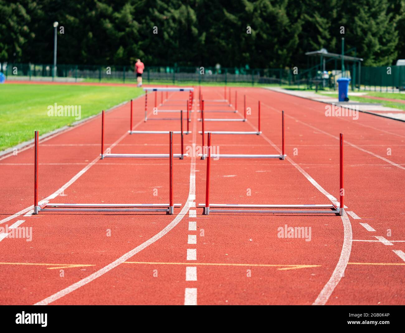 Fallen hurdle on the sprint lane with starting blocks against blurry