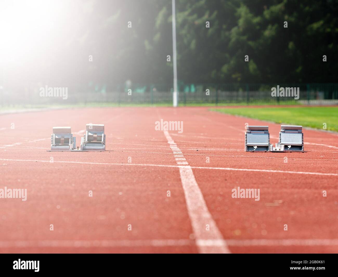 Starting blocks on red running tracks, light reflection an lens flare