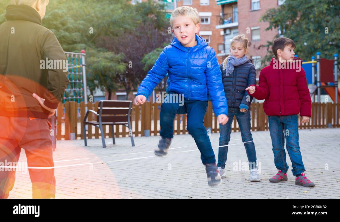 Group of five happy children jumping outdoors., Group of fi…