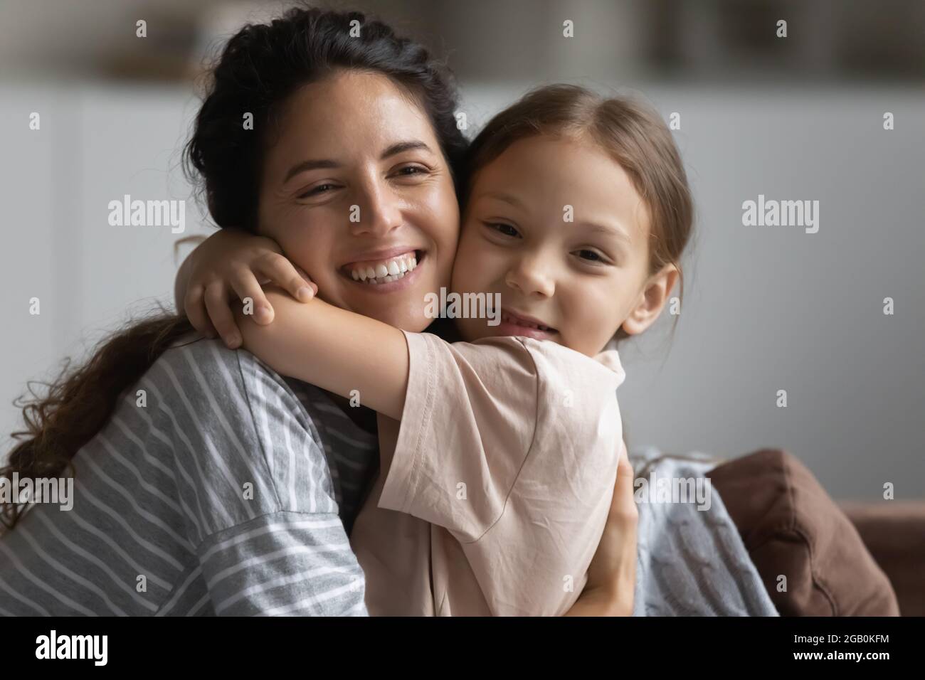 Happy mom embracing cute little daughter girl cheek to cheek Stock ...