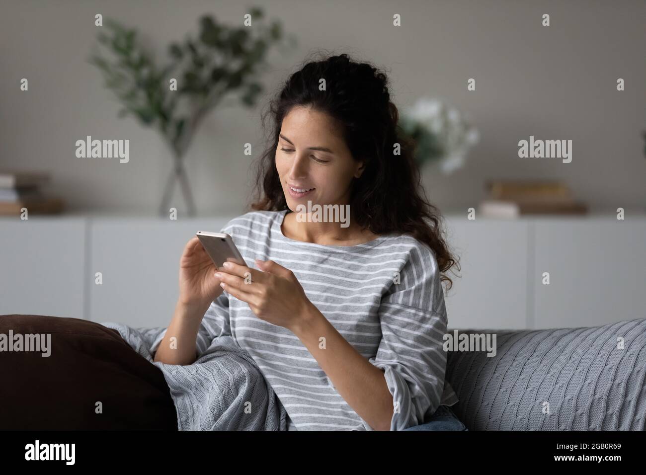 Satisfied mobile phone user receiving message with good news Stock Photo