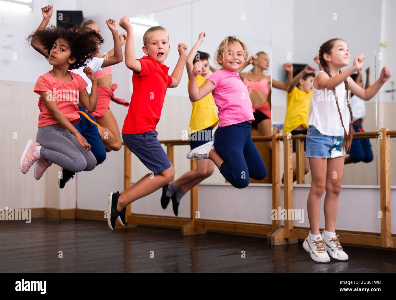 Happy sporty kids jumping together in dance studio Stock Photo - Alamy