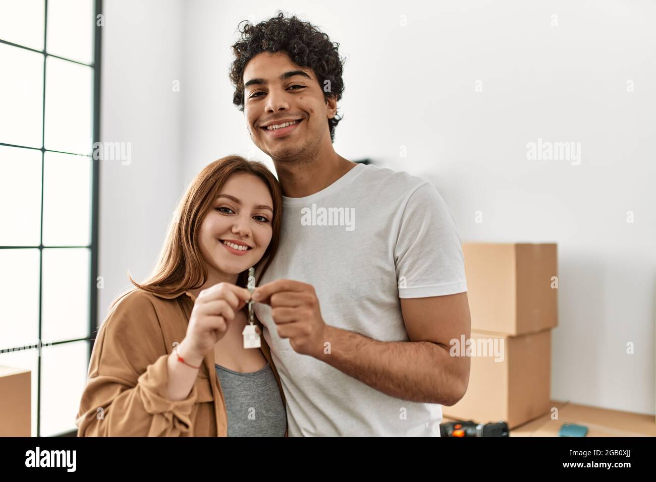 Young couple smiling happy holding key of new home Stock Photo - Alamy