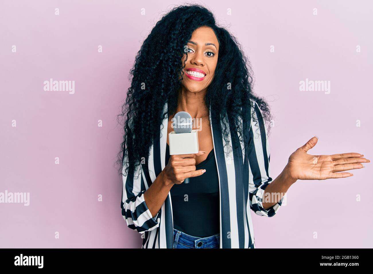 Middle age african american woman holding reporter microphone ...