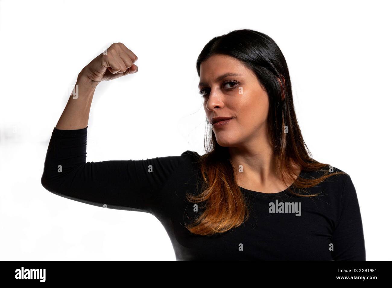 Confident Young Woman Flexes Bicep showing women power Stock Photo