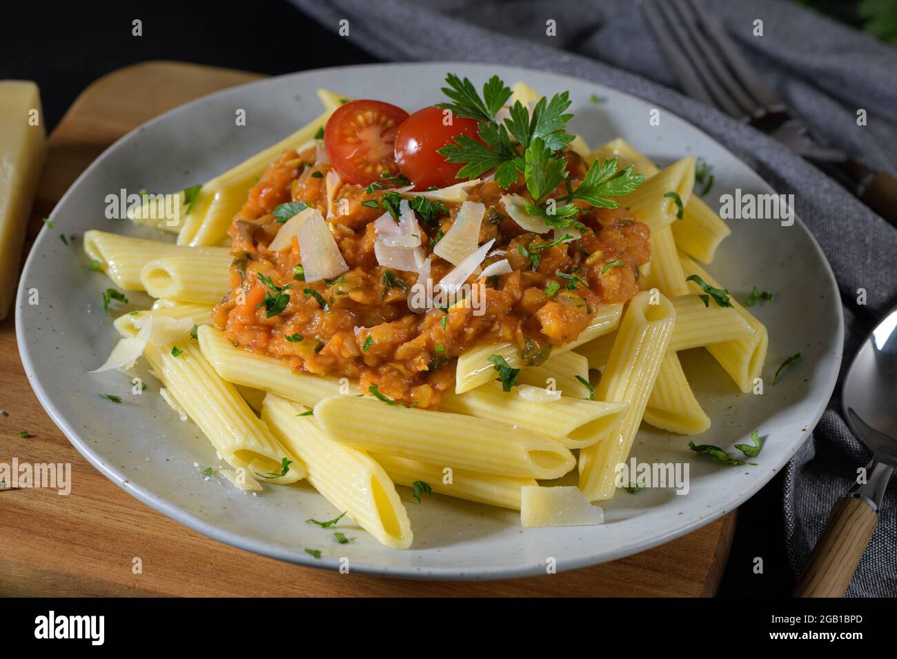 Vegetarian lentil Bolognese sauce penne pasta on a dark background