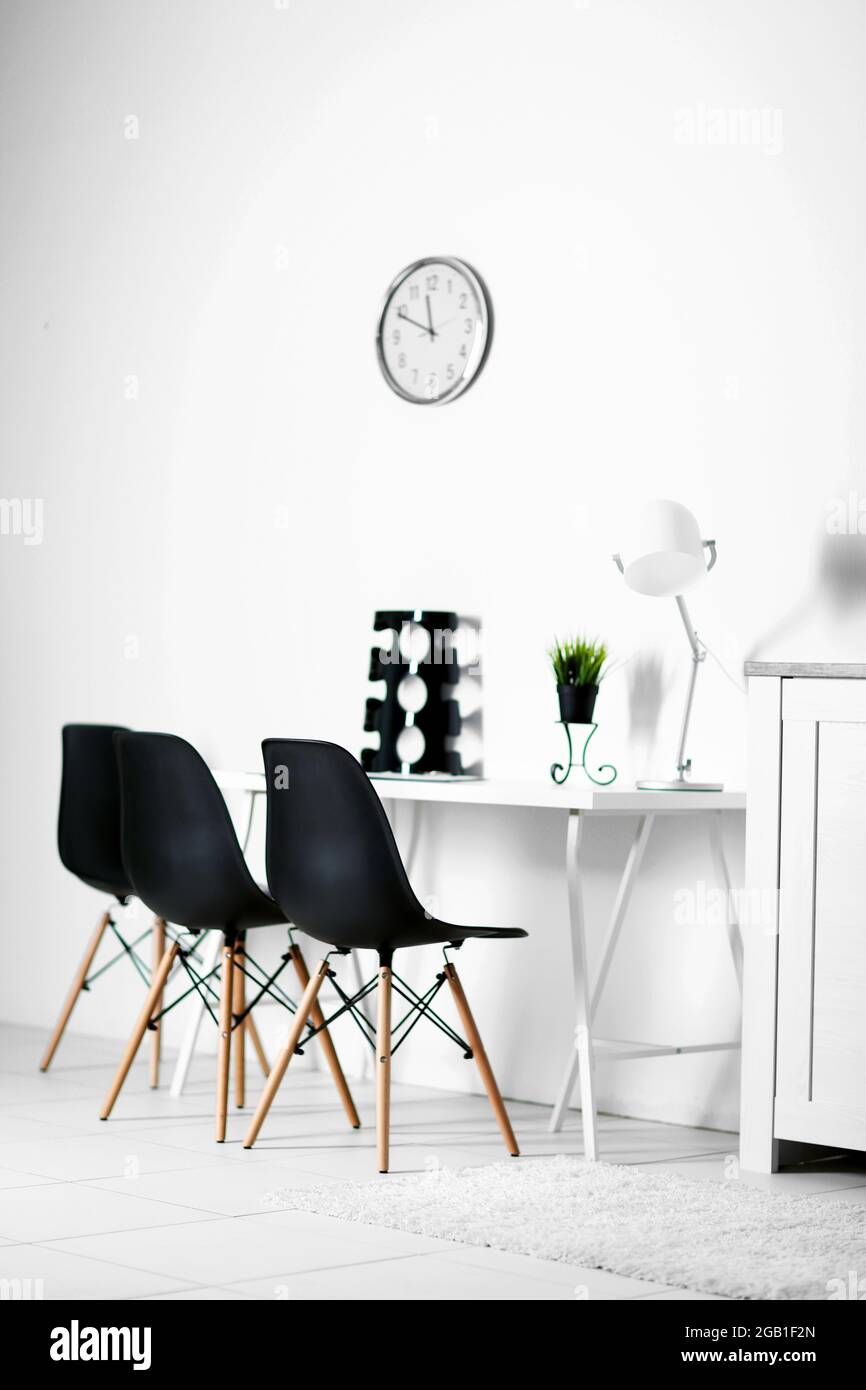 Room interior with clock, chairs and table on white wall background