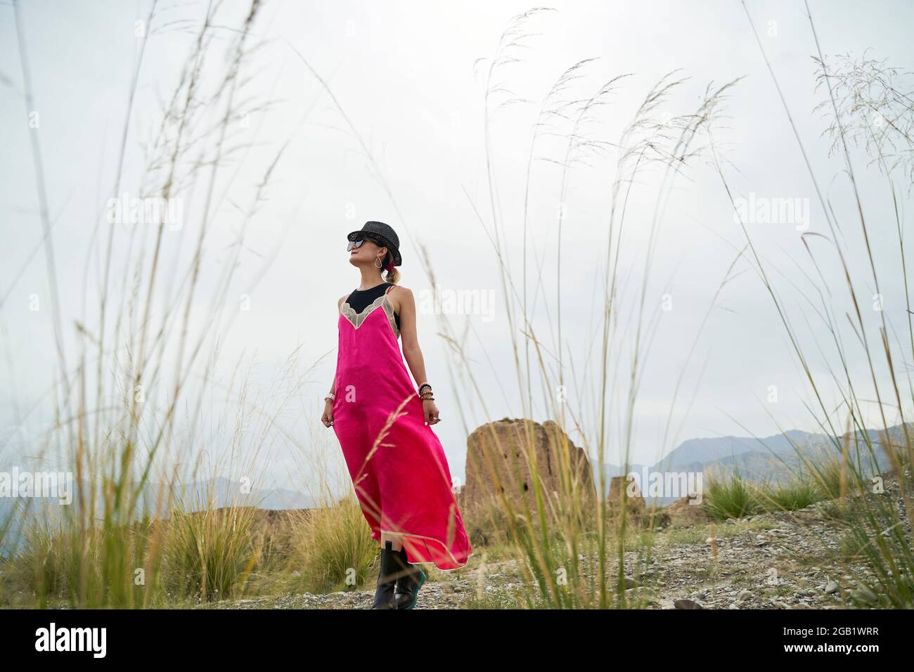 asian woman in red dress walking in a desolate historical site Stock Photo