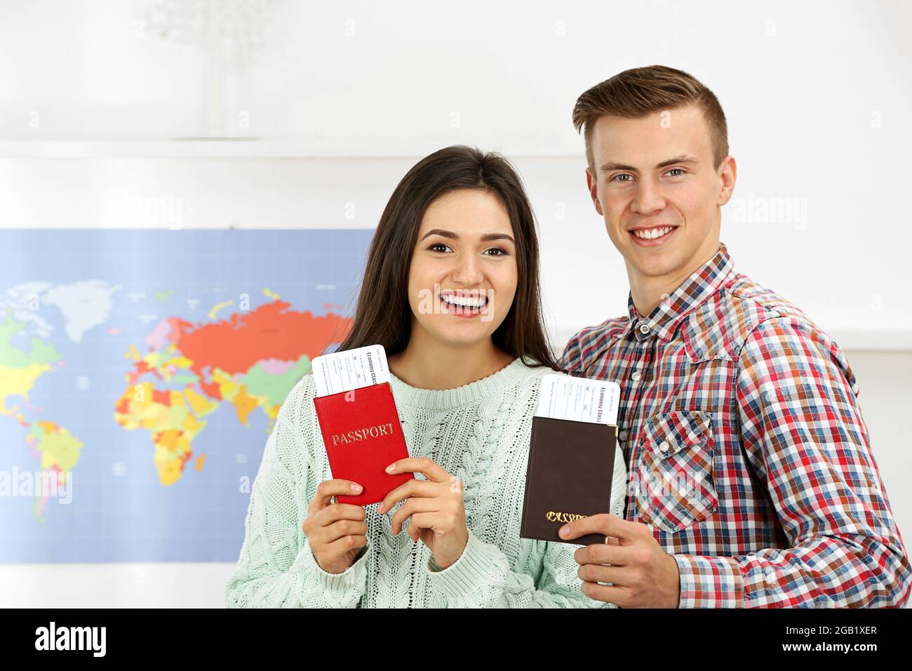 Happy young couple with passports and tickets in the office of travel