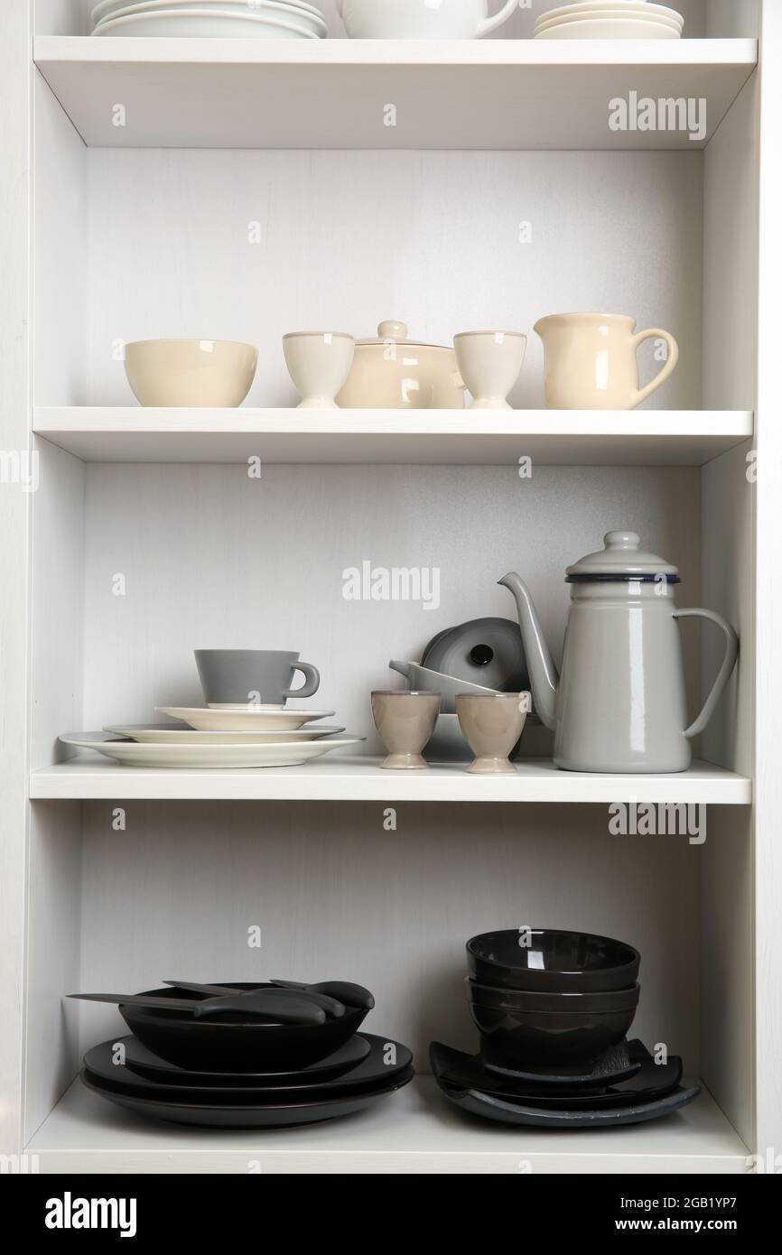 Tableware on shelves in the kitchen cupboard Stock Photo - Alamy