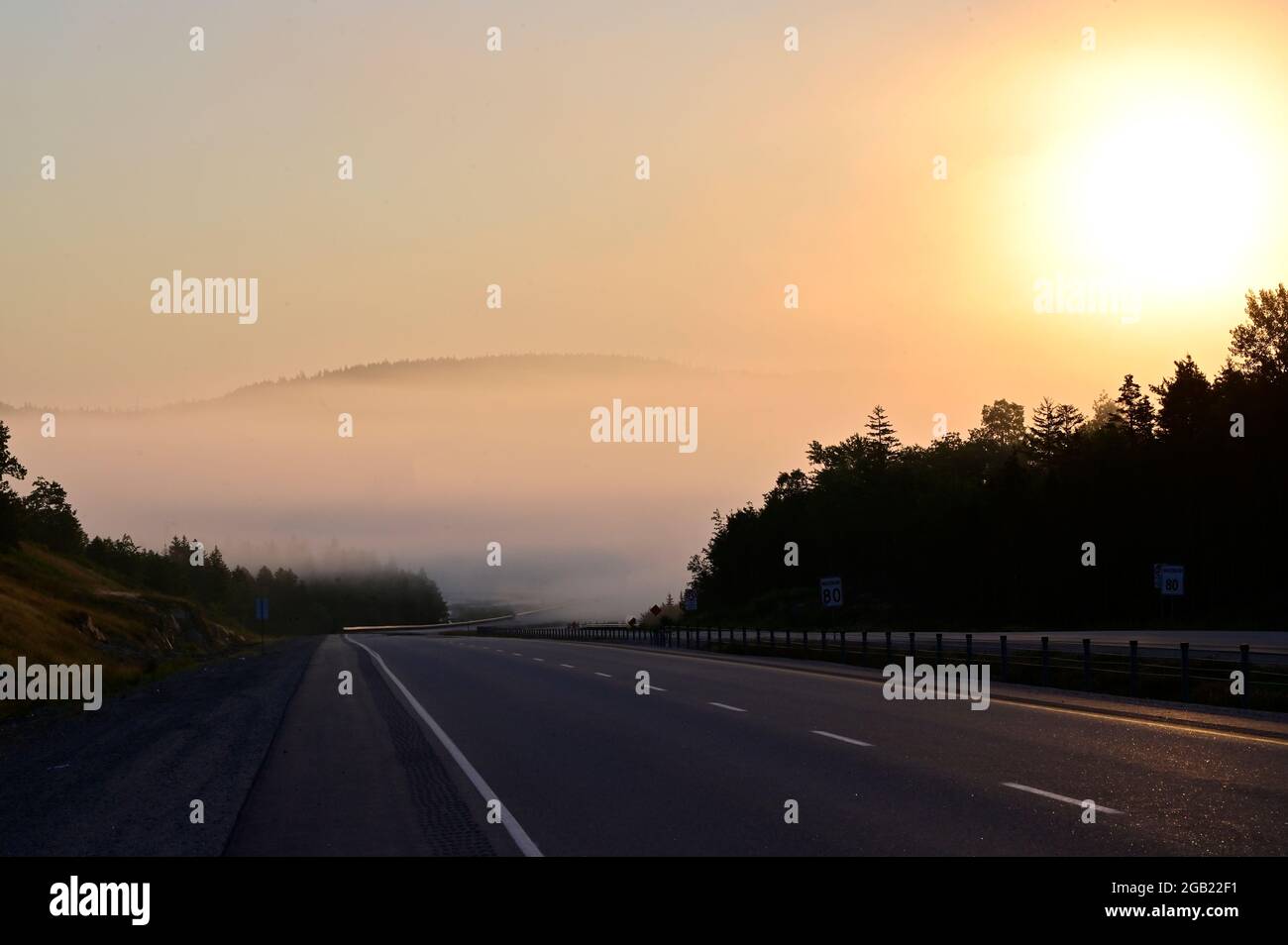Amazing view foggy road during sunrise in early morning Stock Photo - Alamy
