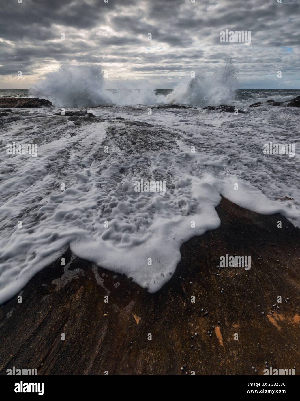 water splashing up onto the rocks along the coastline Stock Photo