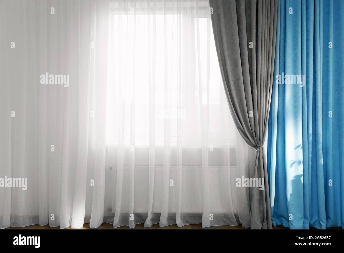 Room window with white, blue and grey curtains Stock Photo - Alamy