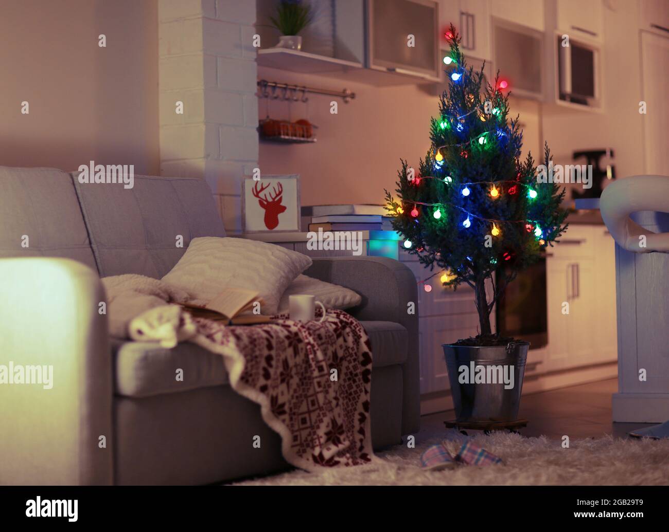 Living room interior with grey sofa and lighted Christmas tree Stock