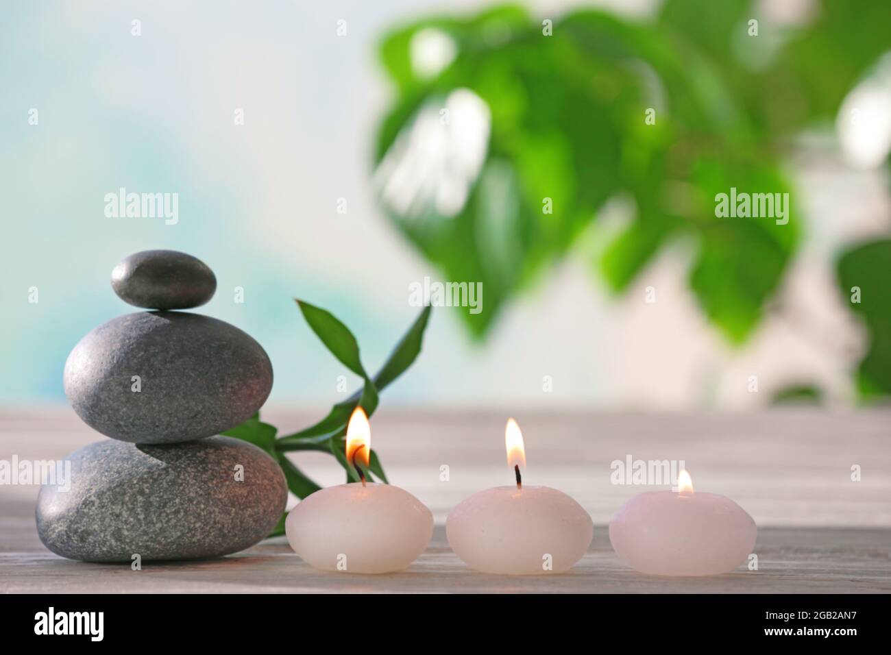 Spa stones with candles and bamboo on blurred background Stock Photo ...