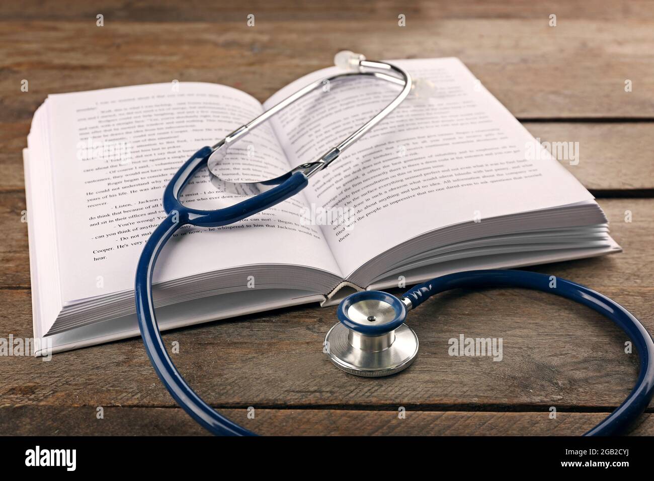 Stethoscope with open book on wooden background. Medical literature concept  Stock Photo - Alamy