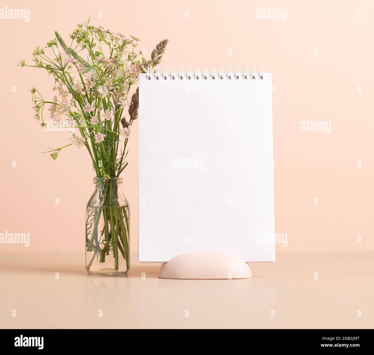 The planner's blank clean notepad stands on the table in vase with ...
