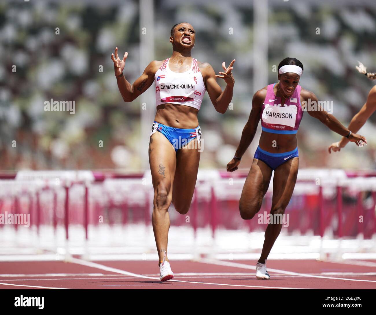 Jasmine CamachoQuinn (L) of Puerto Rico crosses the finish line in the