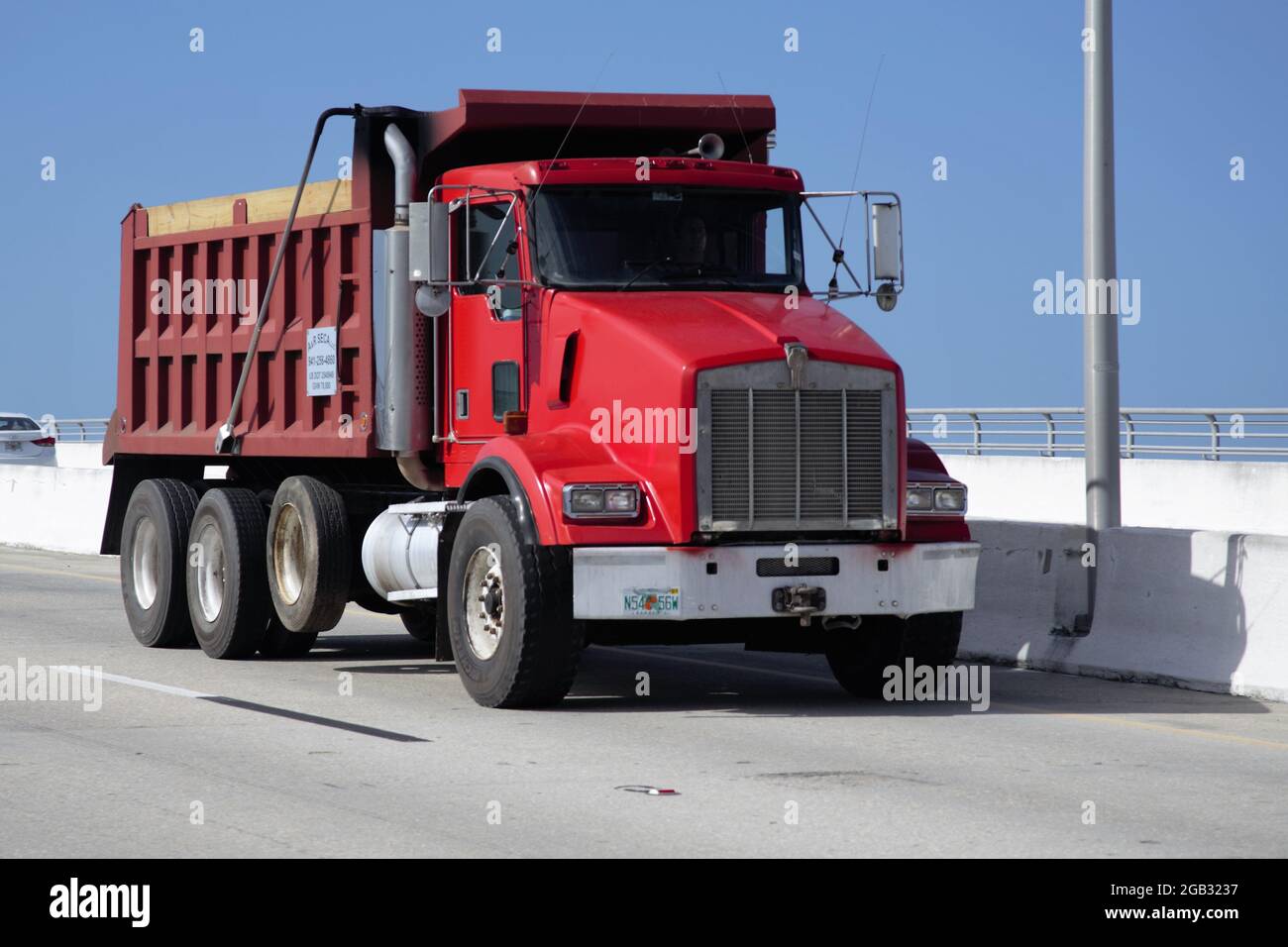 Red Kenworth triaxle dump truck on a freeway in the USA Stock Photo