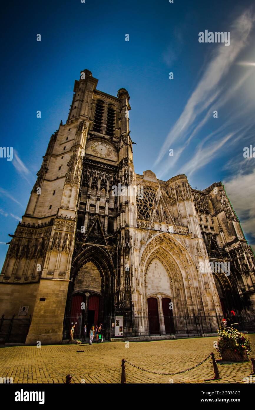 Tourists outside of the Cathedral of Saint Peter and Saint Paul in Troyes France.  View looking up with a blue sky in the background. Copy space Stock Photo