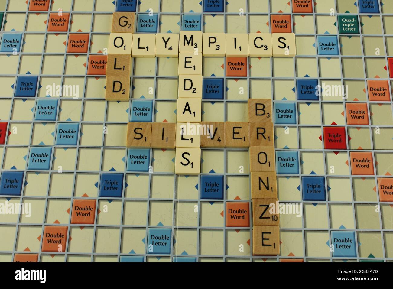 Olympics gold, silver, bronze medals phrase on a scrabble board, with Olympics Medals in white for emphasis Stock Photo