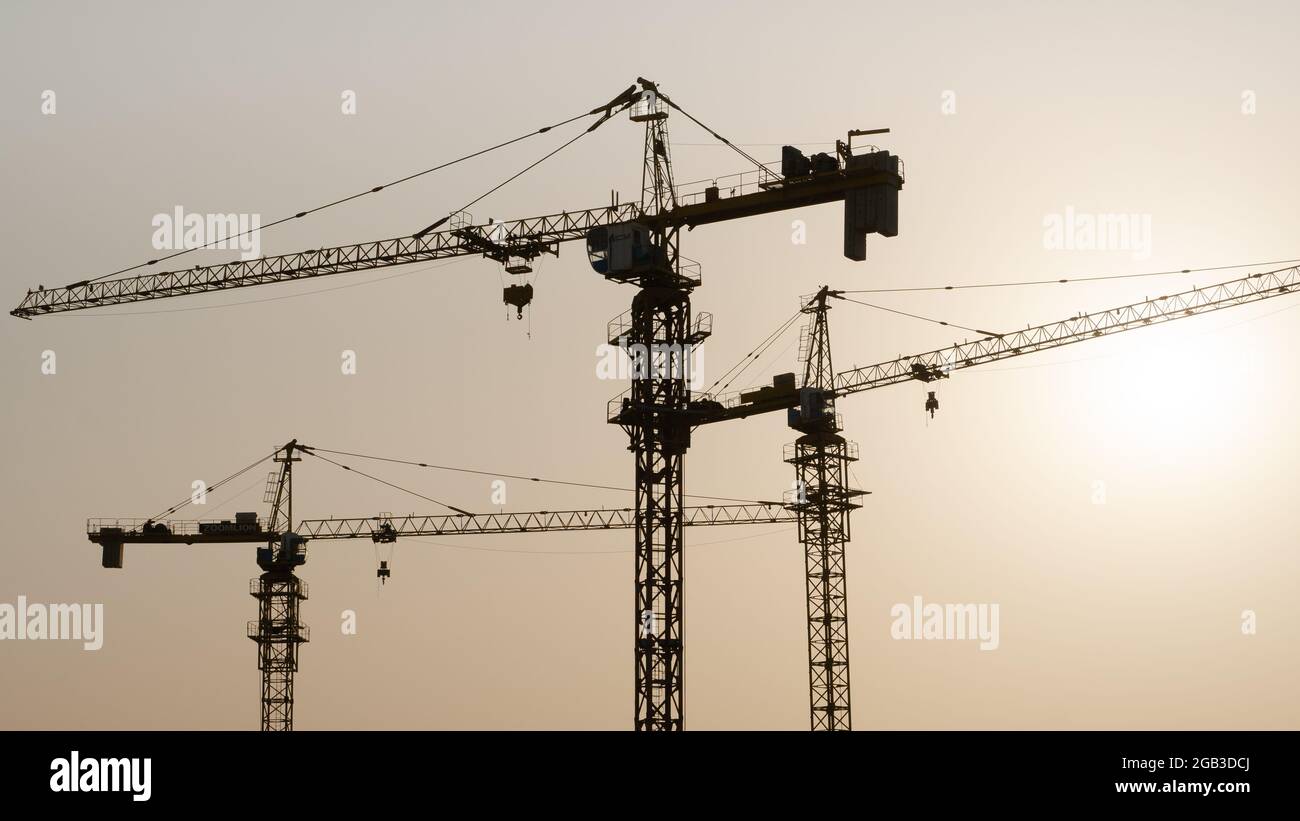 Tower crane at building construction site silhouette during sunrise ...