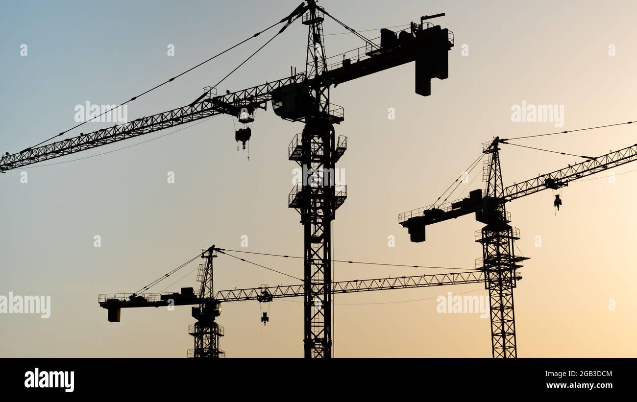 Tower crane at building construction site silhouette during sunrise ...